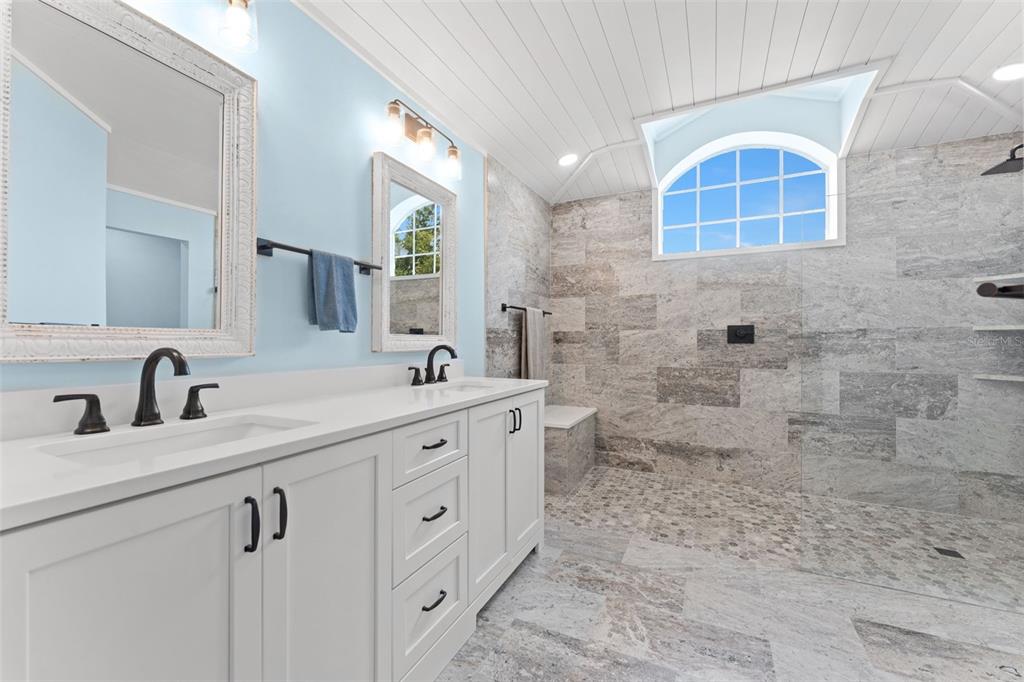 A bathroom features a double vanity with white cabinets and a large walk-in stone shower — 846 MARLEY DRIVE, PORT ORANGE, FL
