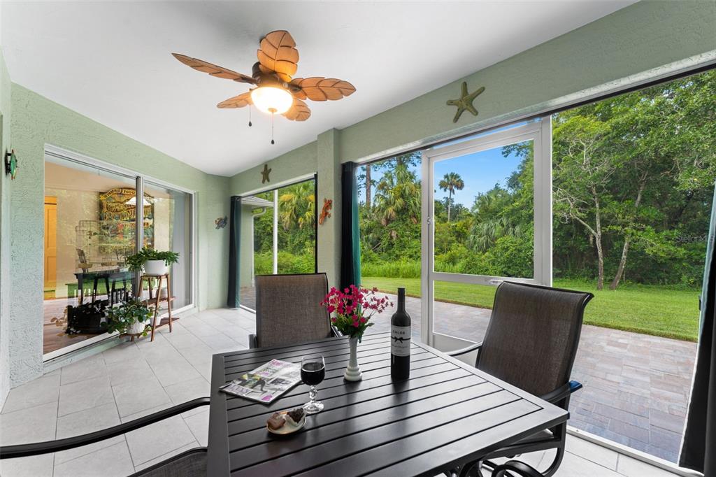 A covered patio features a dining set, ceiling fan, and sliding glass doors overlooking a yard — 846 MARLEY DRIVE, PORT ORANGE, FL
