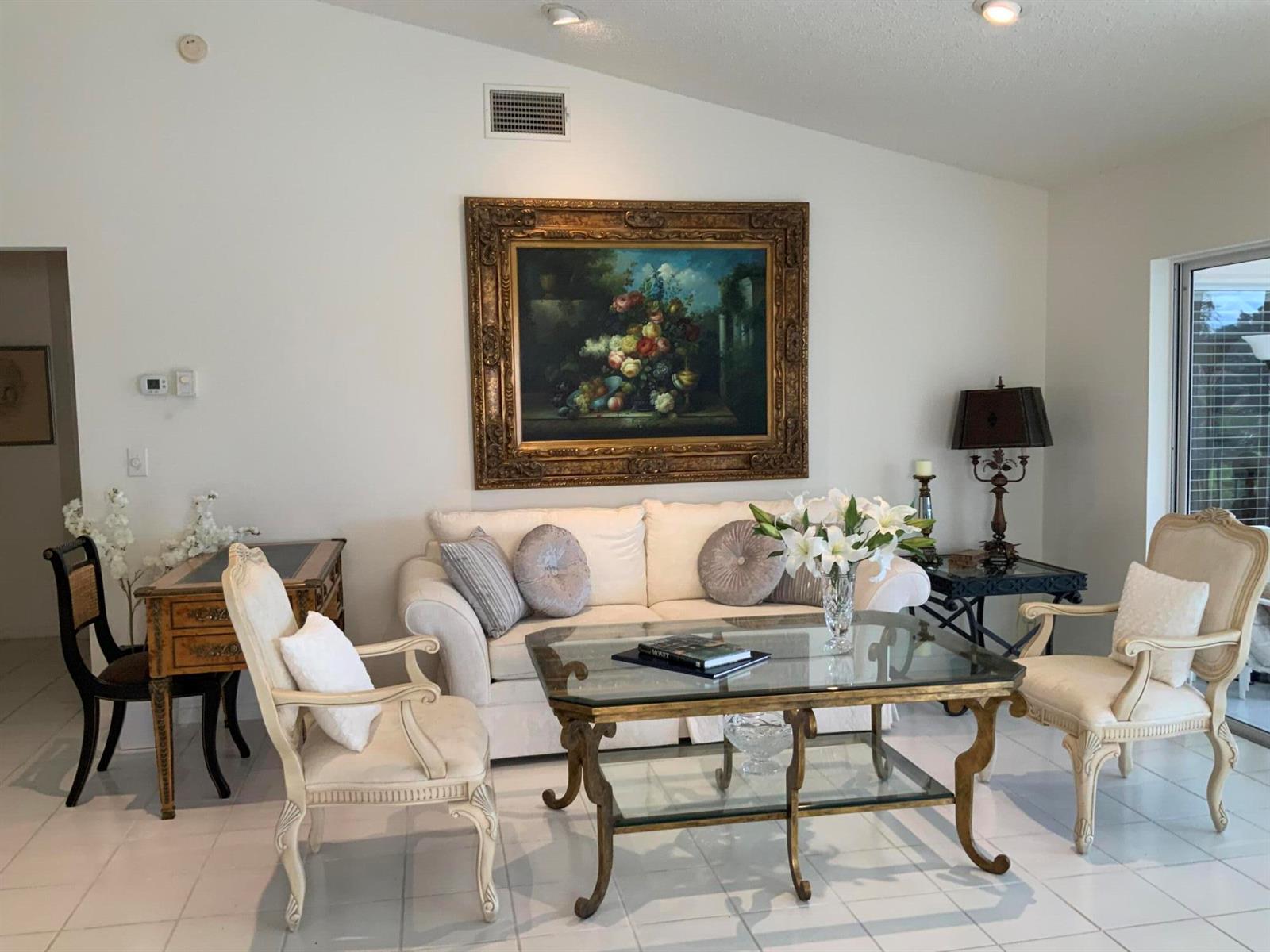 A living room features a white sofa, glass coffee table, and ornate gold-framed wall art — 14356 Emerald Lake Drive # 3, Delray Beach FL 33446, DELRAY BEACH, FL
