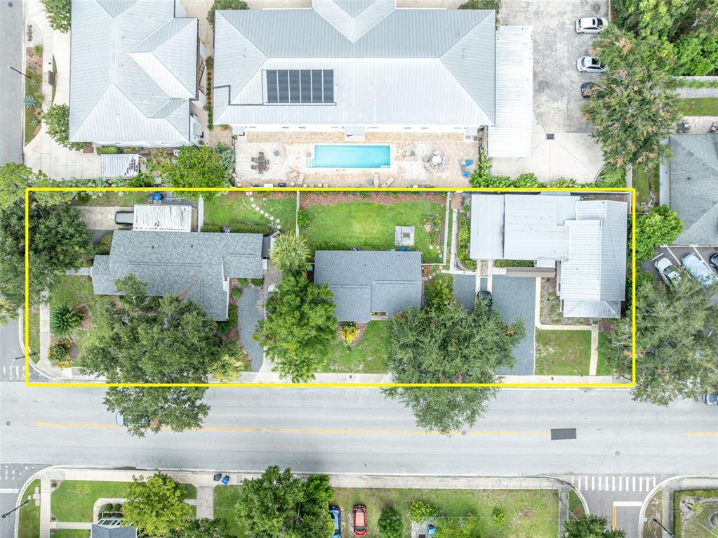 This aerial view shows three houses with gray roofs and a shared backyard — 540 N PENNSYLVANIA AVENUE, WINTER PARK, FL