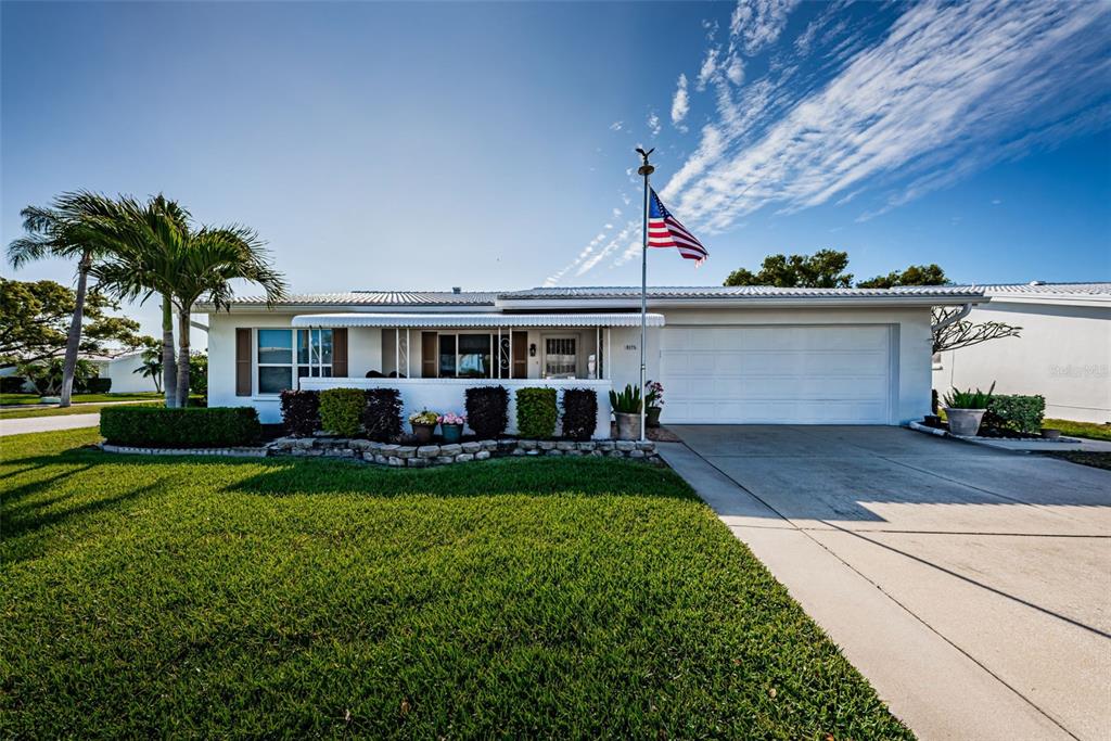 A single-story house with a white exterior, a two-car garage, and a front lawn — 9175 42ND STREET N, PINELLAS PARK, FL
