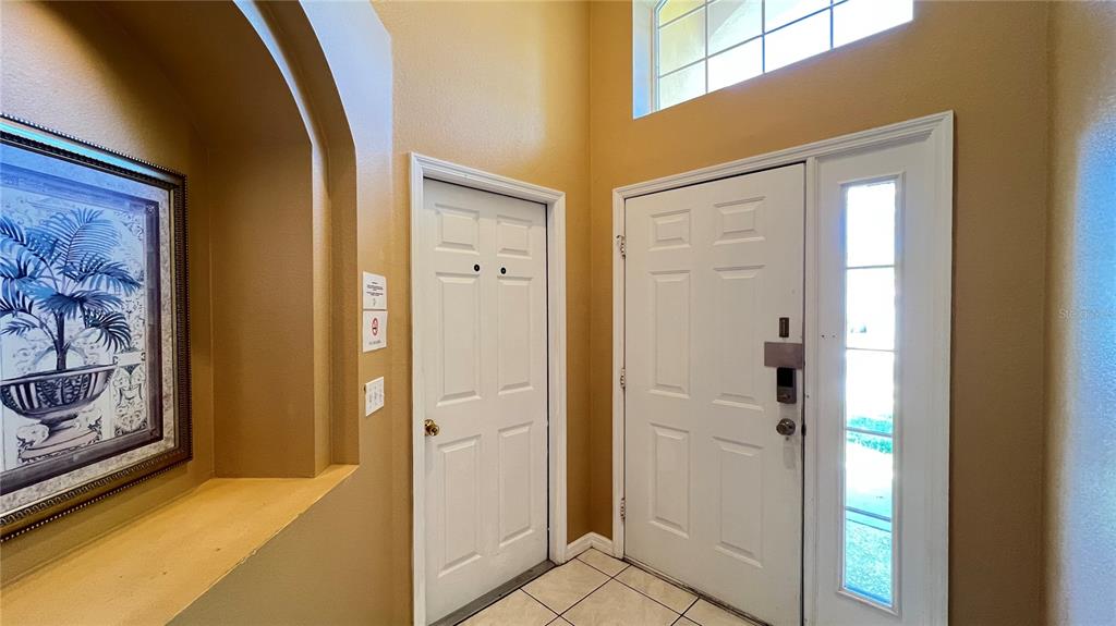 An entryway features a white front door with a sidelight, tile flooring, and a wall niche — 2756 LIDO KEY DRIVE, KISSIMMEE, FL