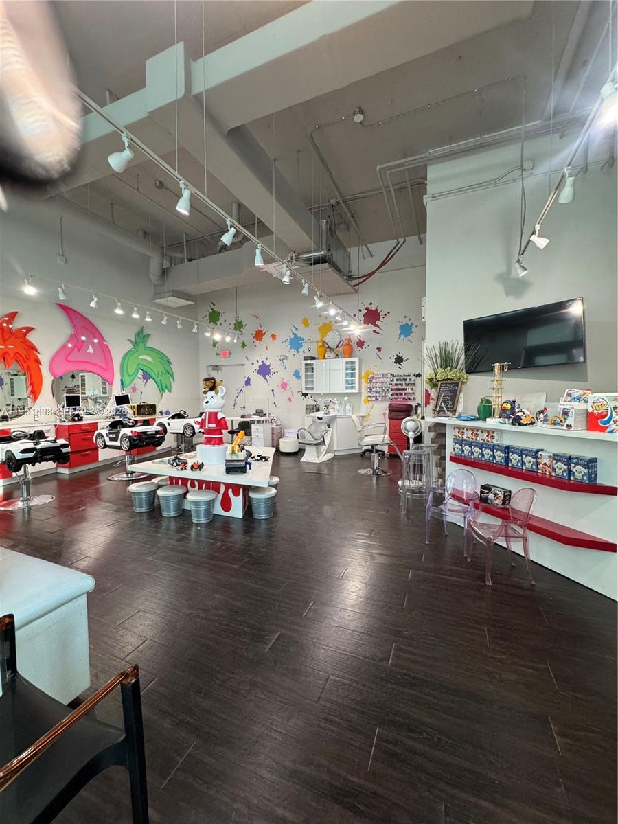 A children's hair salon features car-shaped styling chairs, colorful wall art, and dark wood flooring — 000 NE Confidential, Miami FL 33137, MIAMI, FL