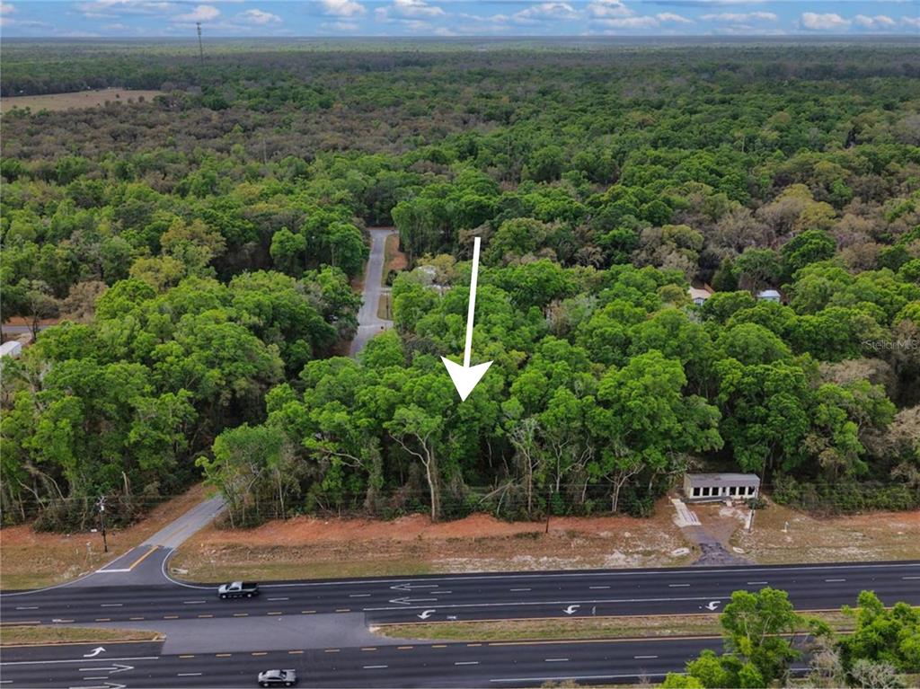 An aerial view shows a wooded lot situated between a road and a highway — 000 NW US HWY 19, FANNING SPRINGS, FL