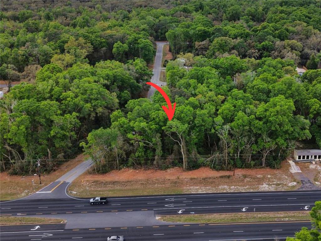 An aerial view shows a wooded lot adjacent to a multi-lane highway — 000 NW US HWY 19, FANNING SPRINGS, FL