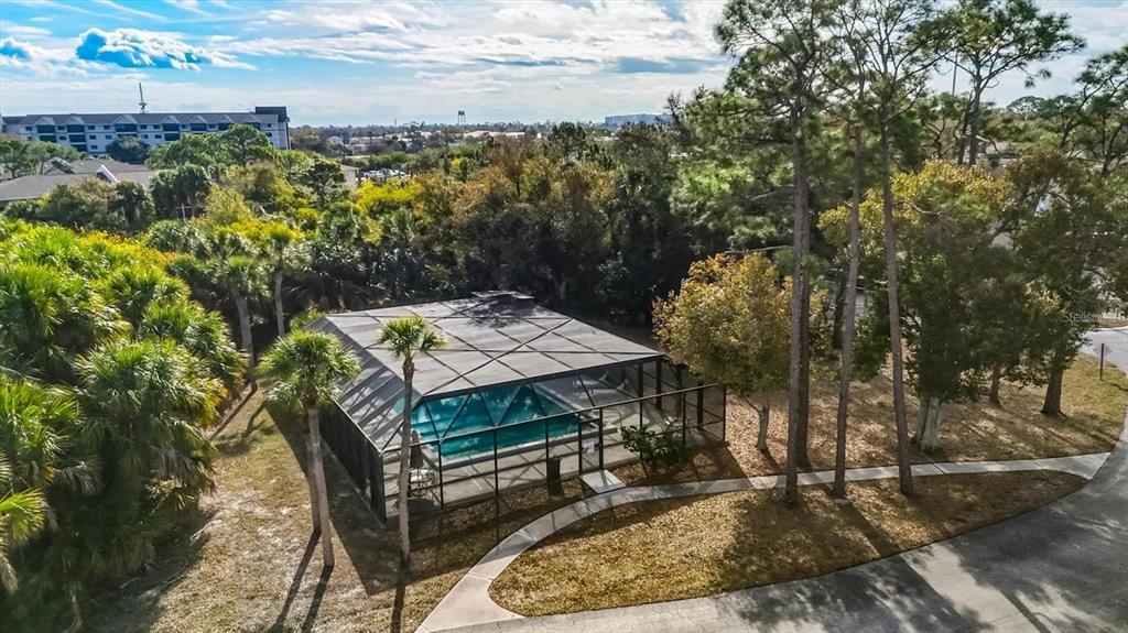 An aerial view of a screened-in swimming pool surrounded by trees and a paved walkway — 22481 WESTCHESTER BOULEVARD UNIT B31, PUNTA GORDA, FL
