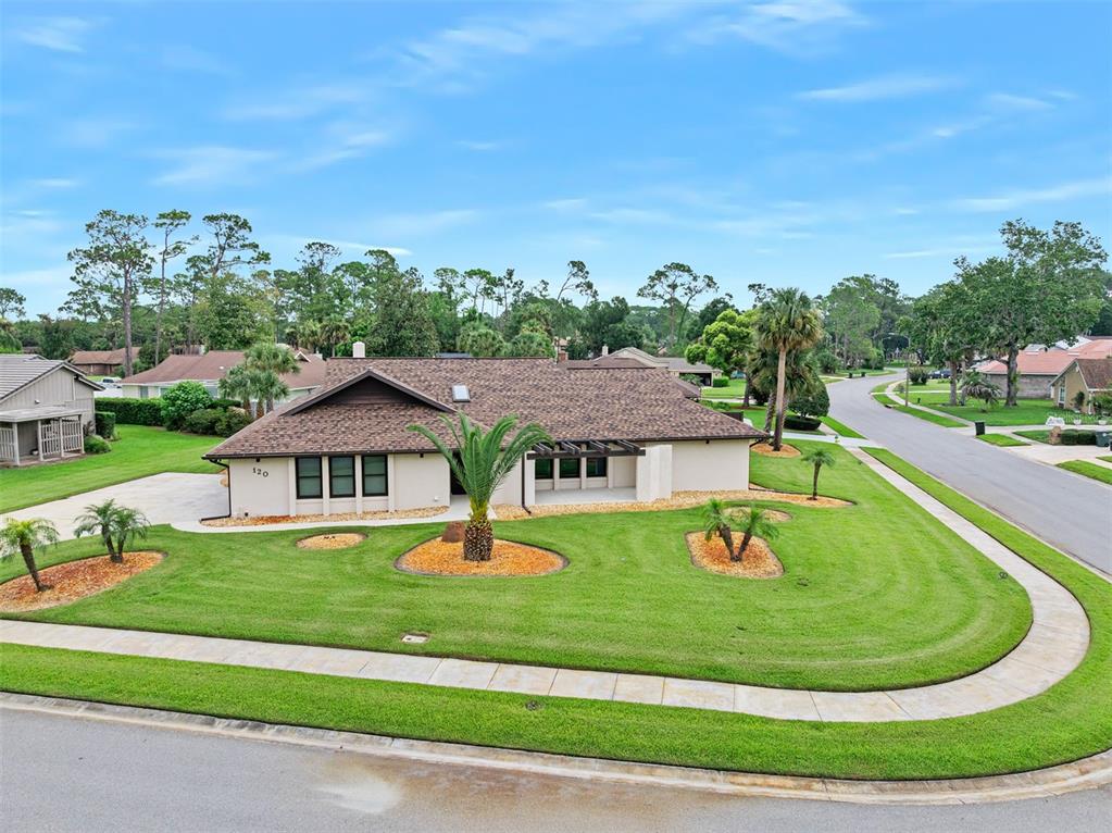 An aerial view shows a house with solar panels, a screened-in pool, and a fenced yard — 120 PEACHTREE CIRCLE, DAYTONA BEACH, FL