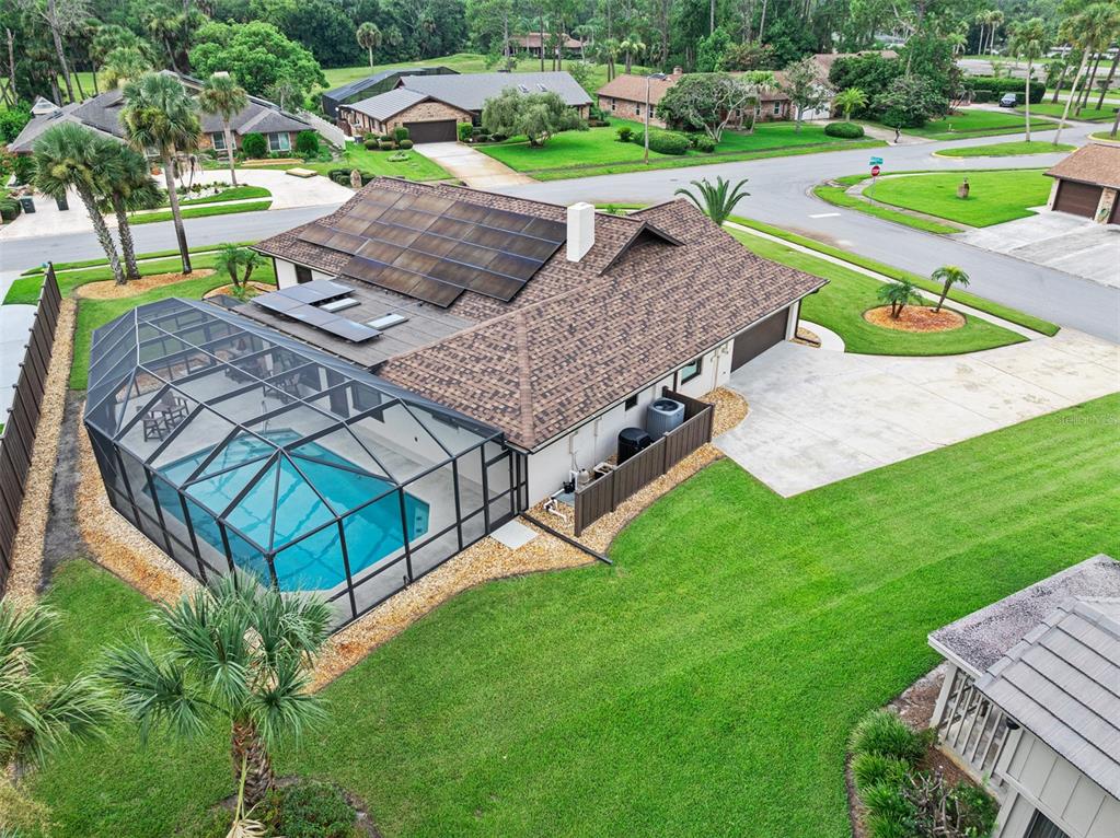 A rustic kitchen features light wood cabinetry, granite countertops, and a large island with seating — 120 PEACHTREE CIRCLE, DAYTONA BEACH, FL