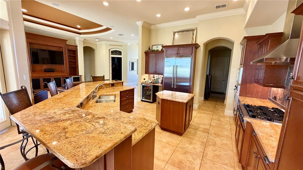 A kitchen features granite countertops, wood cabinetry, stainless steel appliances, and tile flooring — 6717 SW 179TH AVENUE ROAD, DUNNELLON, FL