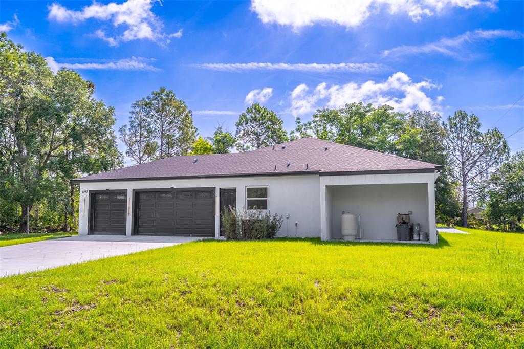 A single-story house exterior features a two-car garage, a covered patio, and a grassy yard — 2943 DECKER AVENUE, ORLANDO, FL