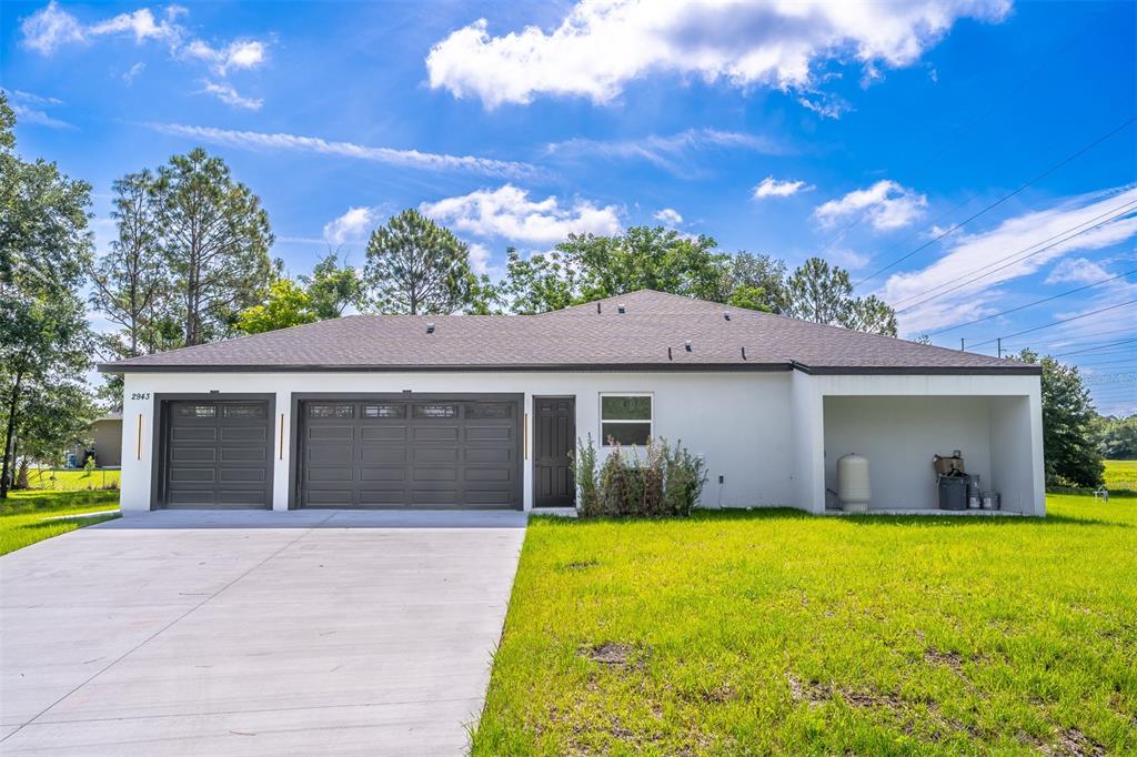 A white single-story house features a three-car garage, a side porch, and a concrete driveway — 2943 DECKER AVENUE, ORLANDO, FL