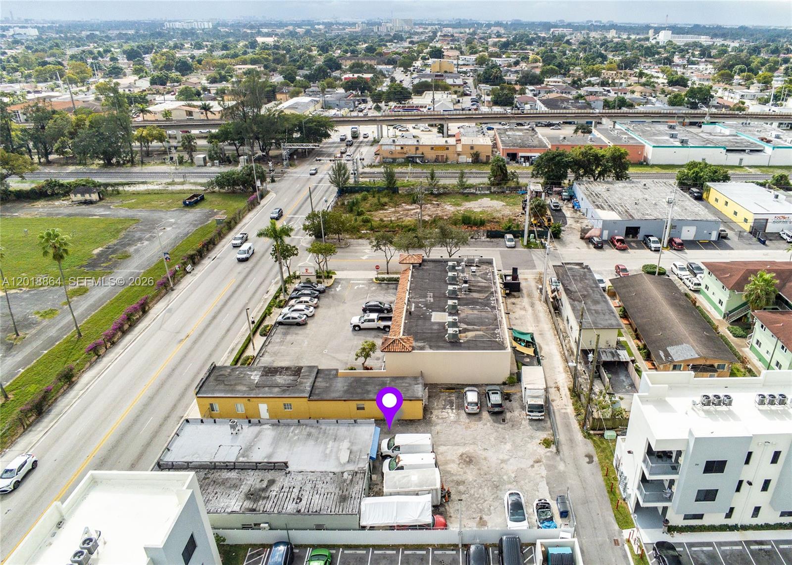 An aerial view shows a commercial building with a parking lot and surrounding urban infrastructure — 2230 Palm Ave, Hialeah FL 33010, HIALEAH, FL