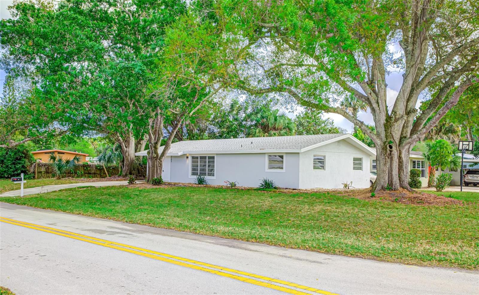 A single-story white house with a shingled roof sits on a grassy lot with trees — 3105 18th Street, Vero Beach FL 32960, VERO BEACH, FL