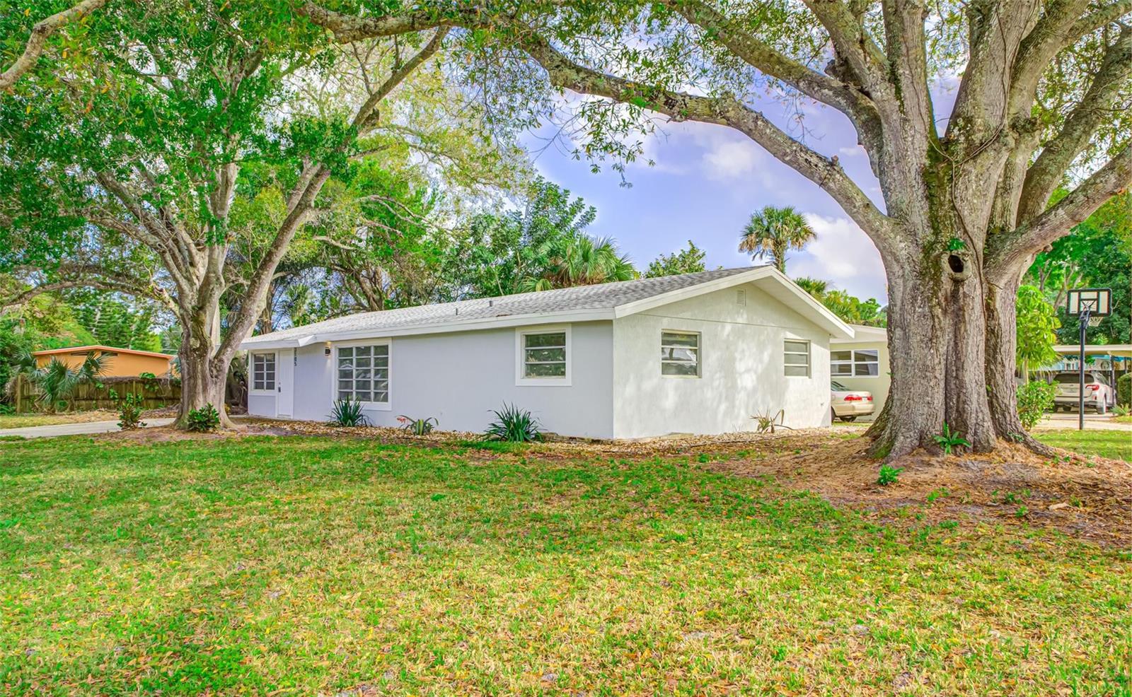 A single-story white house with a gray roof sits on a grassy lot with trees — 3105 18th Street, Vero Beach FL 32960, VERO BEACH, FL