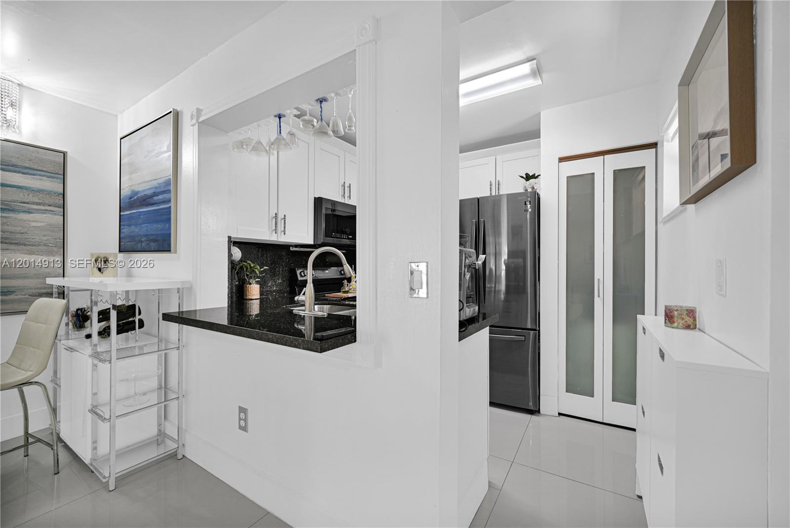 A kitchen features a black granite countertop, white cabinets, and stainless steel appliances — 6535 W 26th Dr # 39, Hialeah FL 33016, HIALEAH, FL