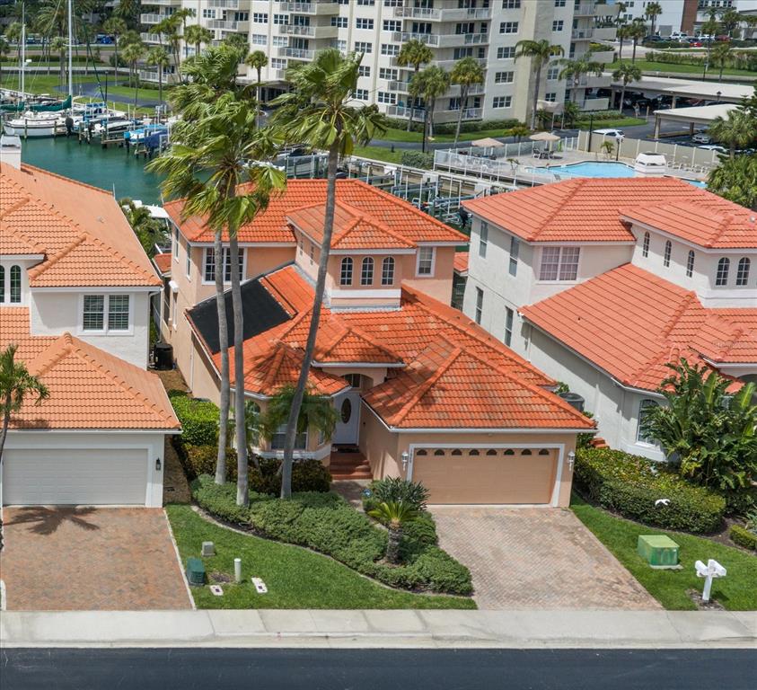 An aerial view of a peach-colored house with a red tile roof and palm trees — 1620 SAND KEY ESTATES COURT, CLEARWATER BEACH, FL