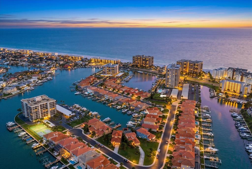 An aerial view of a waterfront residential community with canals, boat docks, and multi-story buildings — 1620 SAND KEY ESTATES COURT, CLEARWATER BEACH, FL