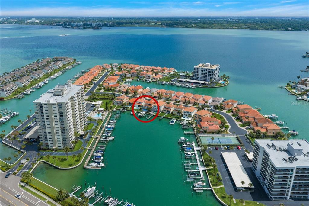 An aerial view shows a waterfront residential complex with a red circle highlighting a specific unit — 1620 SAND KEY ESTATES COURT, CLEARWATER BEACH, FL