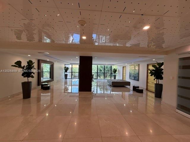A spacious room features polished tile floors, a perforated drop ceiling, and large windows — 540 Brickell Key Dr # 1024, Miami FL 33131, MIAMI, FL