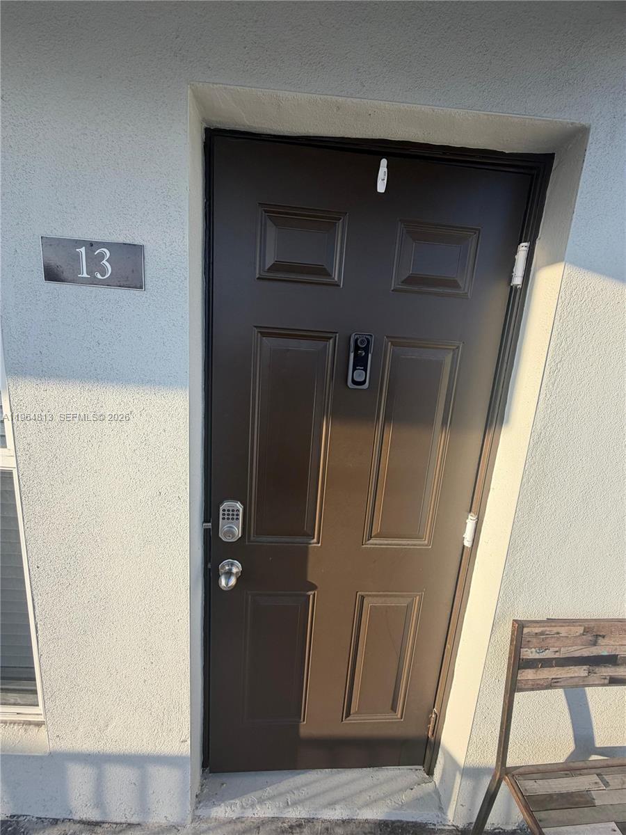 A brown exterior door labeled 13 features a smart lock and a doorbell camera — 1955 NW 5th Pl # 13, Miami FL 33136, MIAMI, FL