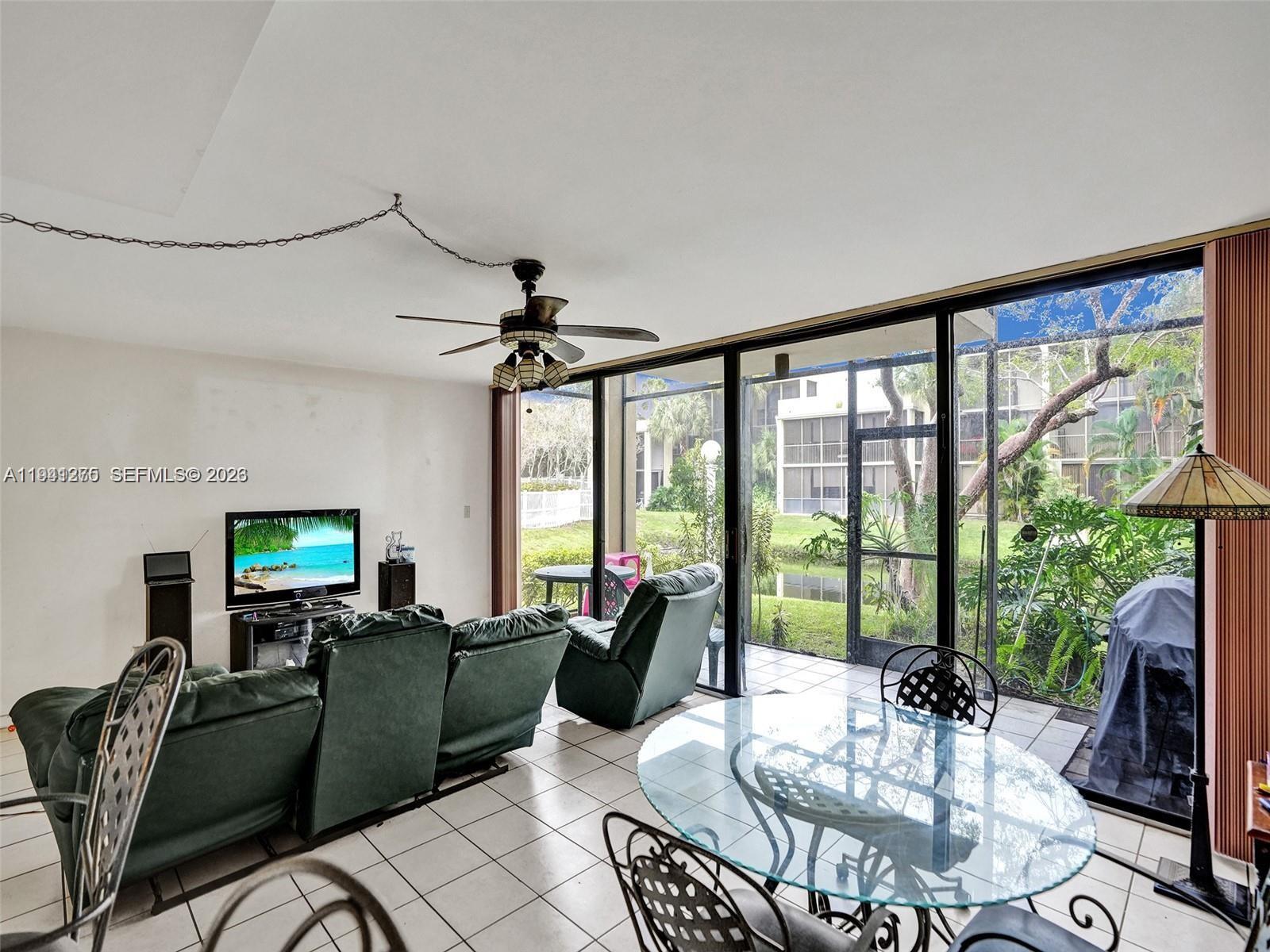 A living and dining area features tile floors, a ceiling fan, and a glass-enclosed patio — 2910 SW 87th Ter # 1701, Davie FL 33328, DAVIE, FL