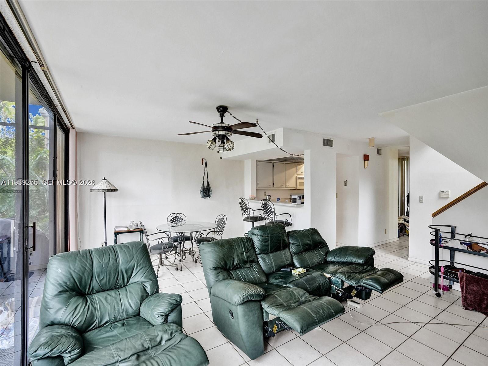A living room with green leather recliners, a dining set, and a kitchen pass-through — 2910 SW 87th Ter # 1701, Davie FL 33328, DAVIE, FL