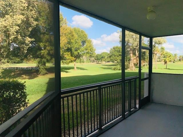 A screened-in porch overlooks a green golf course with trees under a blue sky — 16171 Blatt Blvd # 101, Weston FL 33326, WESTON, FL