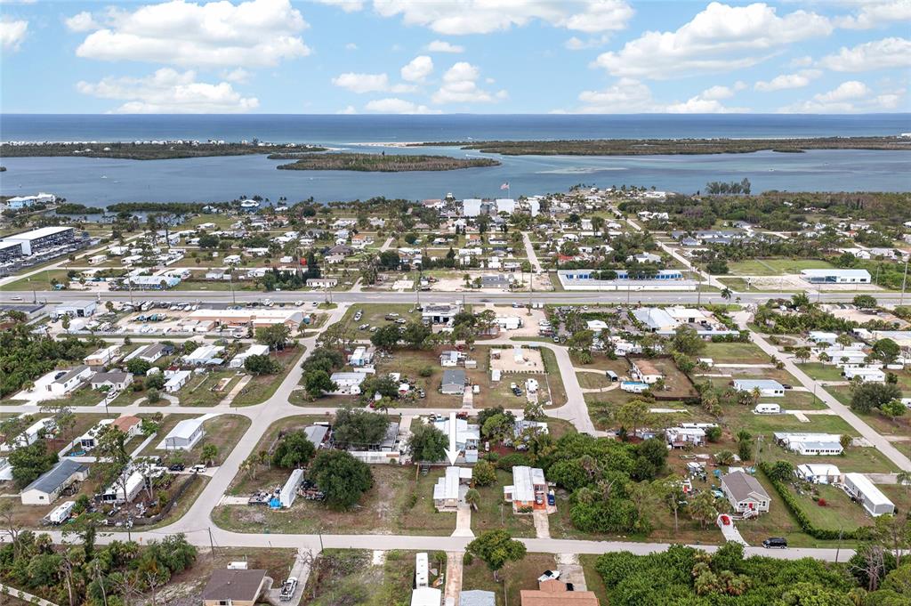 An aerial view shows a residential neighborhood near a coastal waterway and the ocean — 3160 10TH STREET, ENGLEWOOD, FL