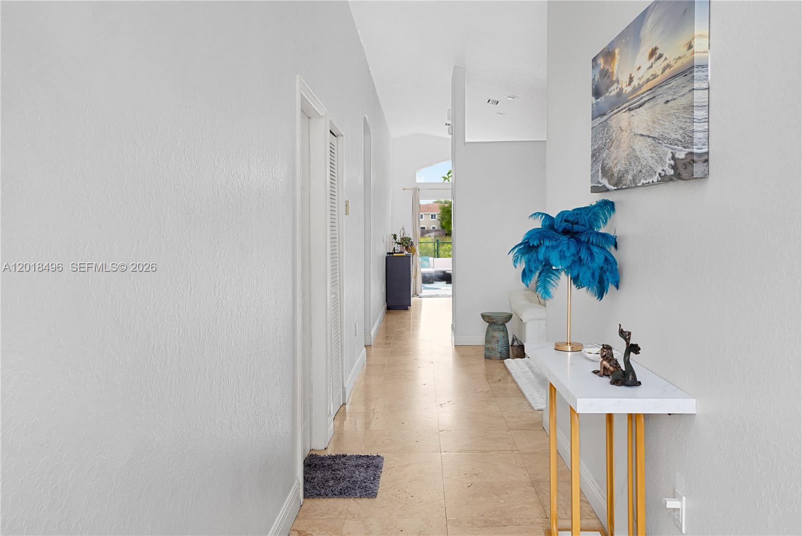 A hallway with tile flooring leads toward an open doorway with a view outside — 1201 SE 20th Rd, Homestead FL 33035, HOMESTEAD, FL