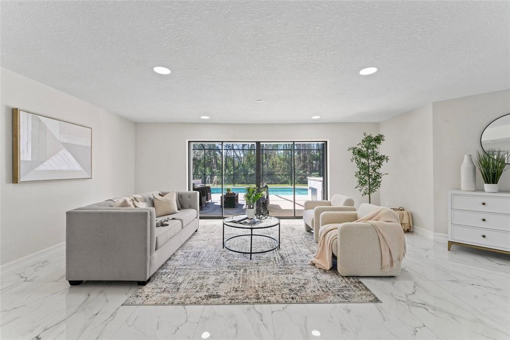 A living room features white marble floors, a gray sofa, two armchairs, and sliding glass doors — 4520 PINE HOLLOW DRIVE, TAMPA, FL