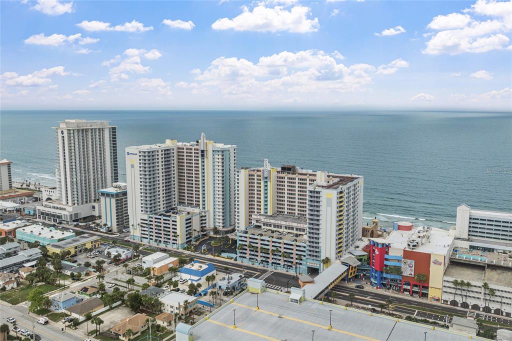 An aerial view of high-rise beachfront hotels and resorts along a coastal city street — 300 N ATLANTIC AVENUE UNIT 405, DAYTONA BEACH, FL
