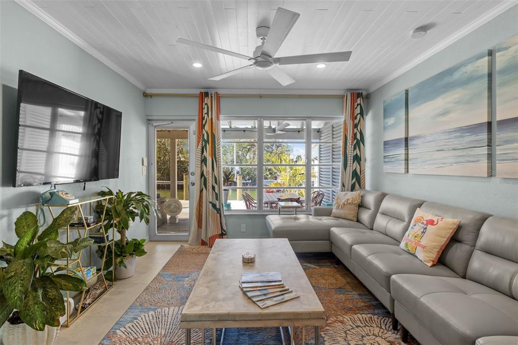 A living room features a grey sectional sofa, a coffee table, and a ceiling fan — 26 SEASIDE COURT, HOLMES BEACH, FL