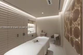 This is a rendering of a spa treatment room featuring a massage table and wood-paneled wall — 102 24th St # 1421, Miami Beach FL 33139, MIAMI BEACH, FL