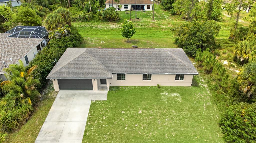 An aerial view of a single-story house with a gray roof and attached garage — 1167 URMEY LANE, NORTH PORT, FL