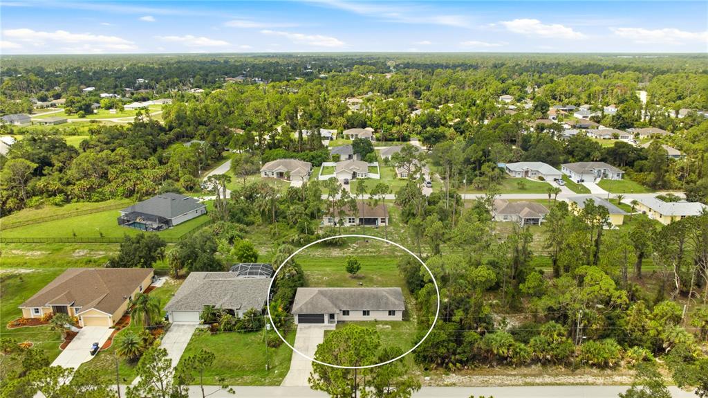 An aerial view shows a single-story house with a driveway in a suburban neighborhood — 1167 URMEY LANE, NORTH PORT, FL
