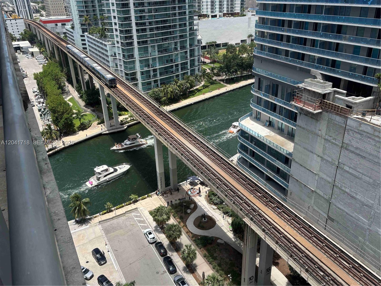 An elevated train track runs over a canal with boats between two tall apartment buildings — 690 SW 1st Ct # 2124, Miami FL 33130, MIAMI, FL