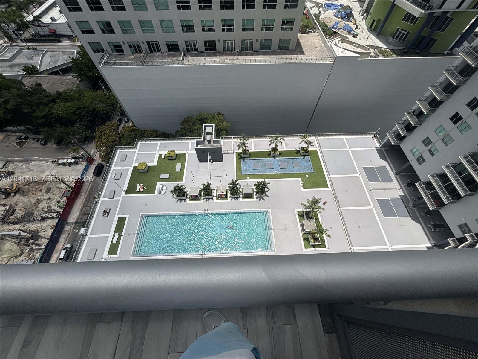 An elevated view shows a building rooftop terrace with a swimming pool and landscaping — 690 SW 1st Ct # 2124, Miami FL 33130, MIAMI, FL