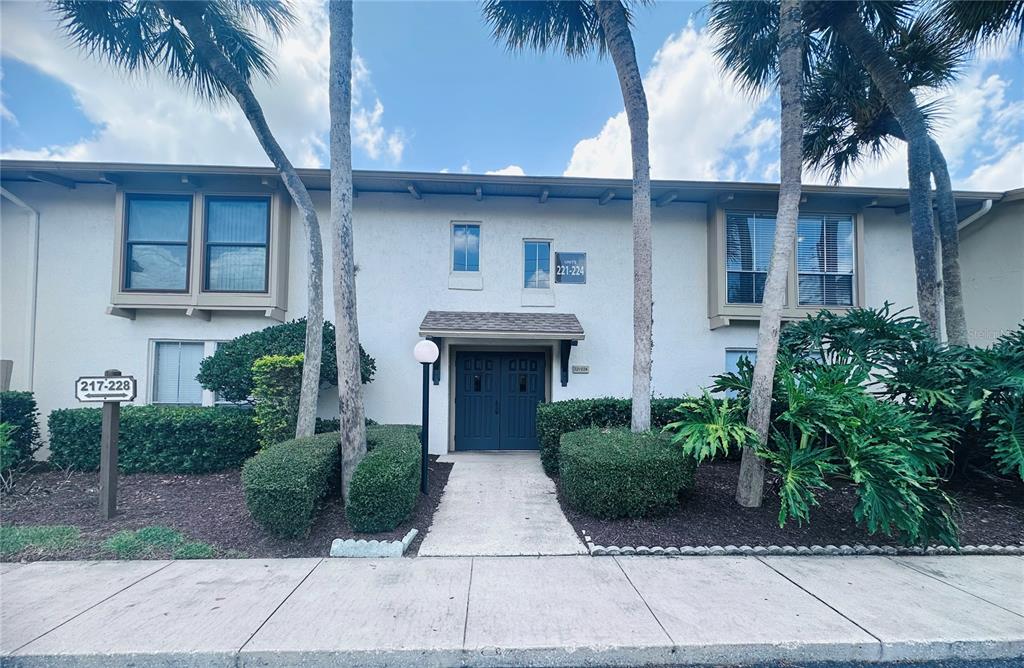 A two-story apartment building exterior features a central entrance, palm trees, and unit signage — 200 MAITLAND AVENUE UNIT 224, ALTAMONTE SPRINGS, FL
