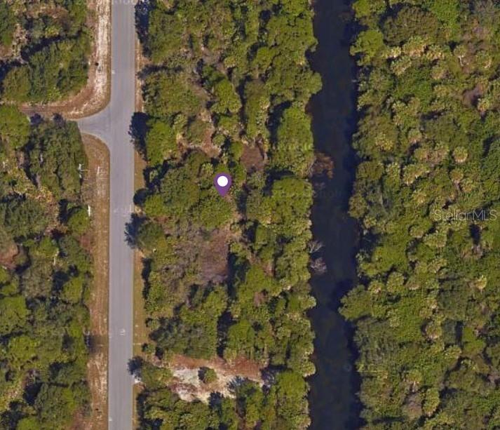 This aerial map view shows a wooded lot situated between a road and a canal — 34 YORKSHIRE STREET, PORT CHARLOTTE, FL