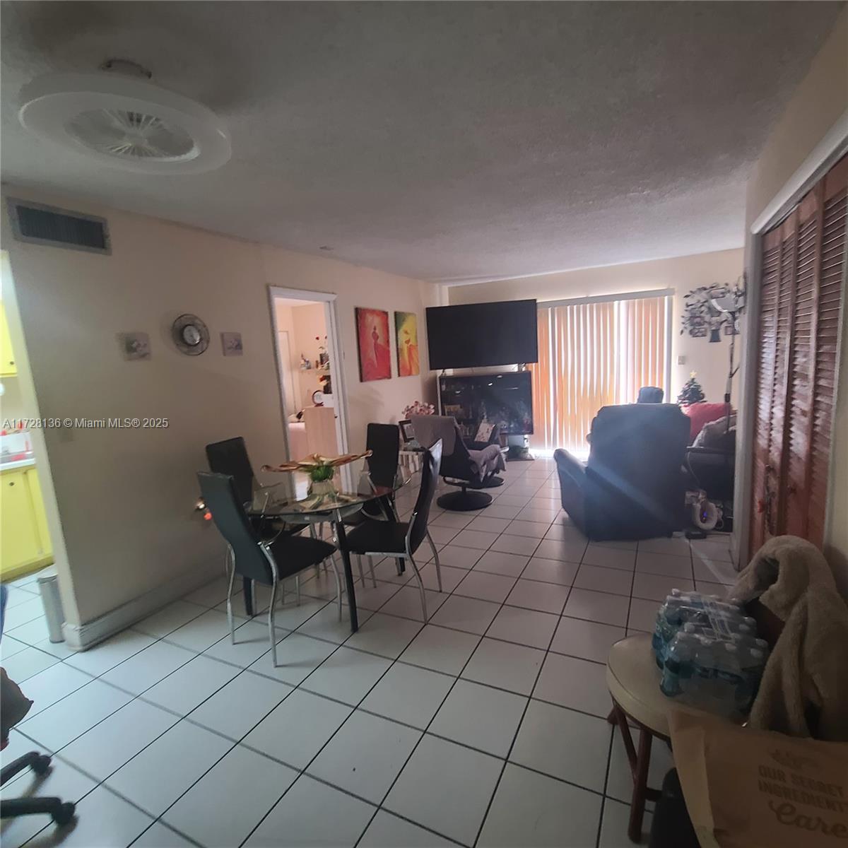 A living and dining area features white tile flooring, a ceiling fan, and sliding glass doors — 4803 NW 7th St # 14, Miami FL 33126, MIAMI, FL