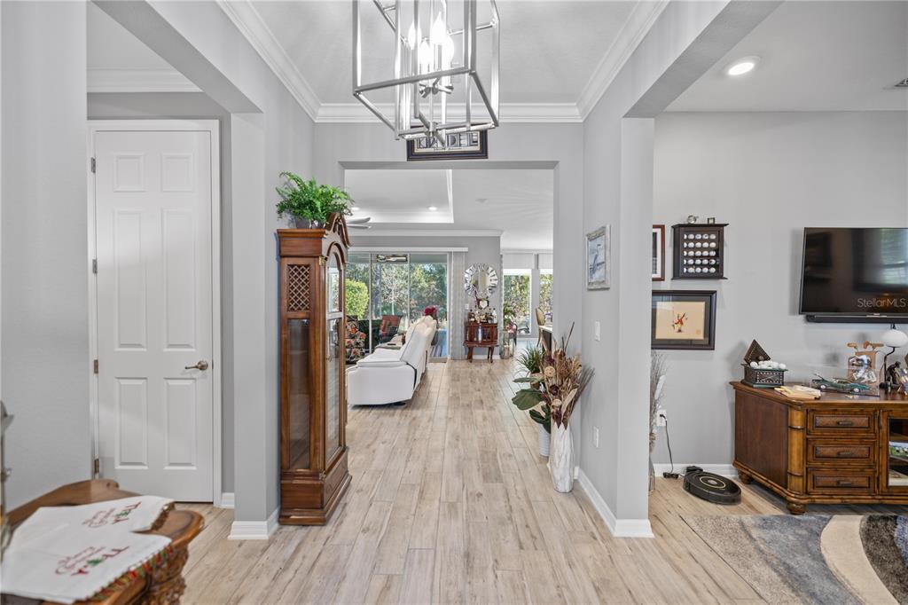 A view through a foyer into a living room with wood-look tile flooring — 9343 SW 102ND AVENUE ROAD, OCALA, FL