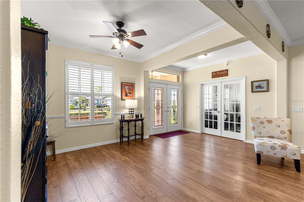 A bright foyer features wood-look flooring, a ceiling fan, double entry doors, and French doors — 8875 SE 132ND PLACE, SUMMERFIELD, FL