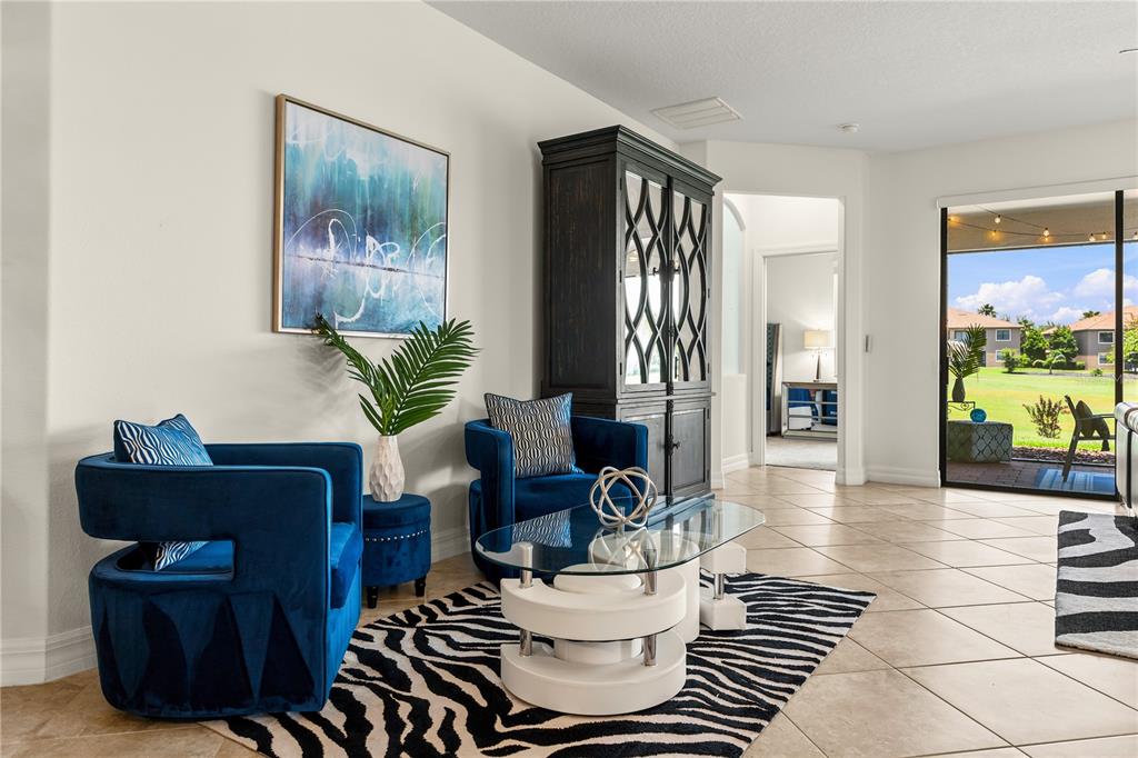 A living area features two blue velvet chairs, a glass coffee table, and zebra-print rug — 1375 PALMETTO DUNES STREET, DAVENPORT, FL