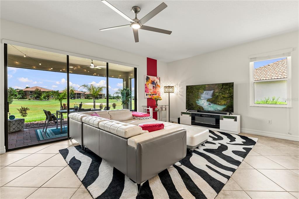 A living room with a white sectional, zebra-print rug, and sliding glass doors to a patio — 1375 PALMETTO DUNES STREET, DAVENPORT, FL