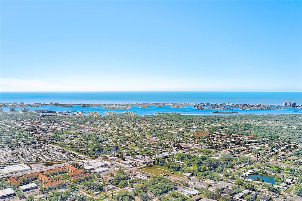 An aerial view shows a coastal residential area with a bay and the ocean beyond — 10540 77TH TERRACE UNIT 109, SEMINOLE, FL