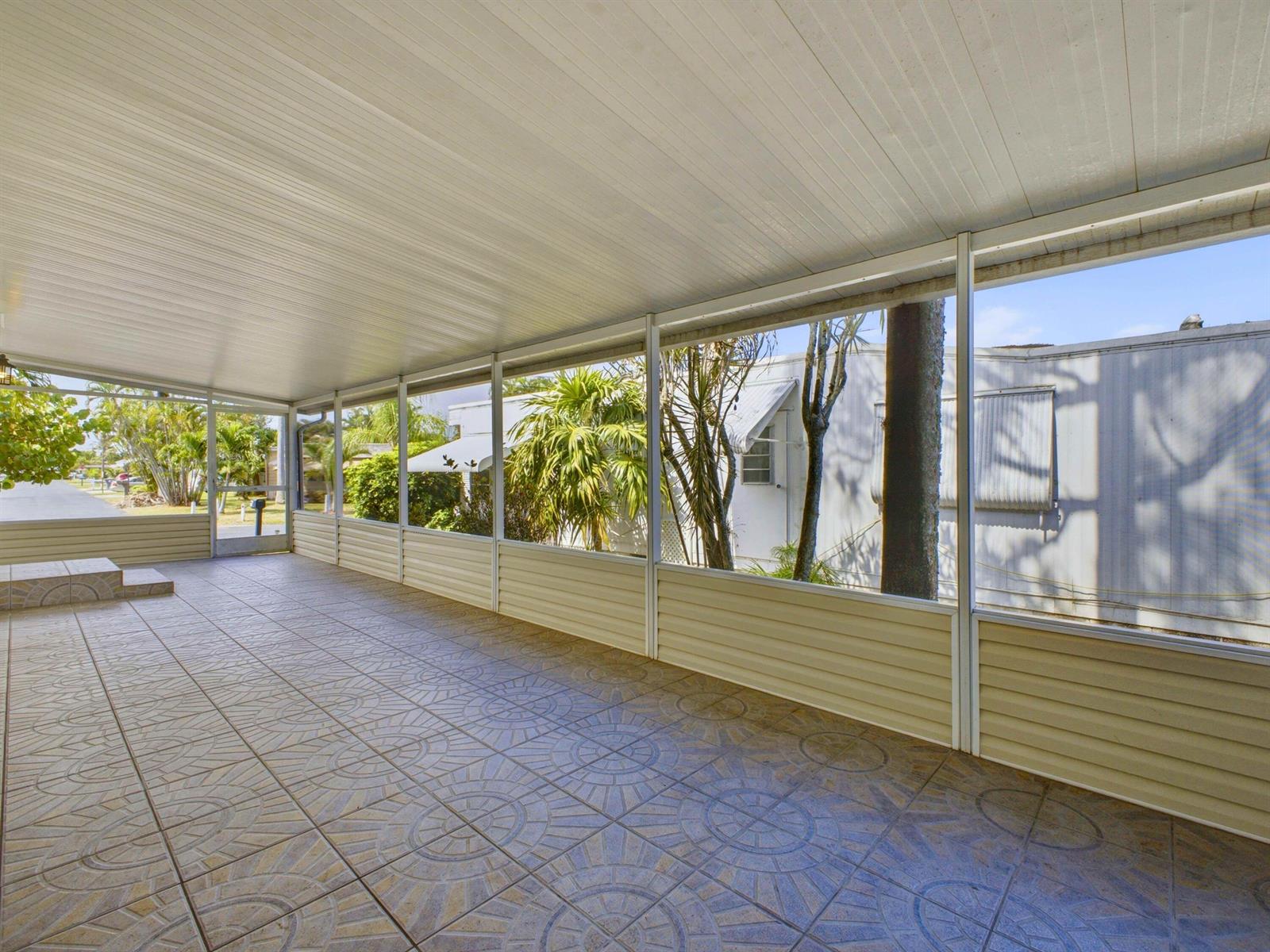 A covered patio with tiled flooring, screened walls, and a white ceiling — 4185 N Shady Lane, Boynton Beach FL 33436, BOYNTON BEACH, FL
