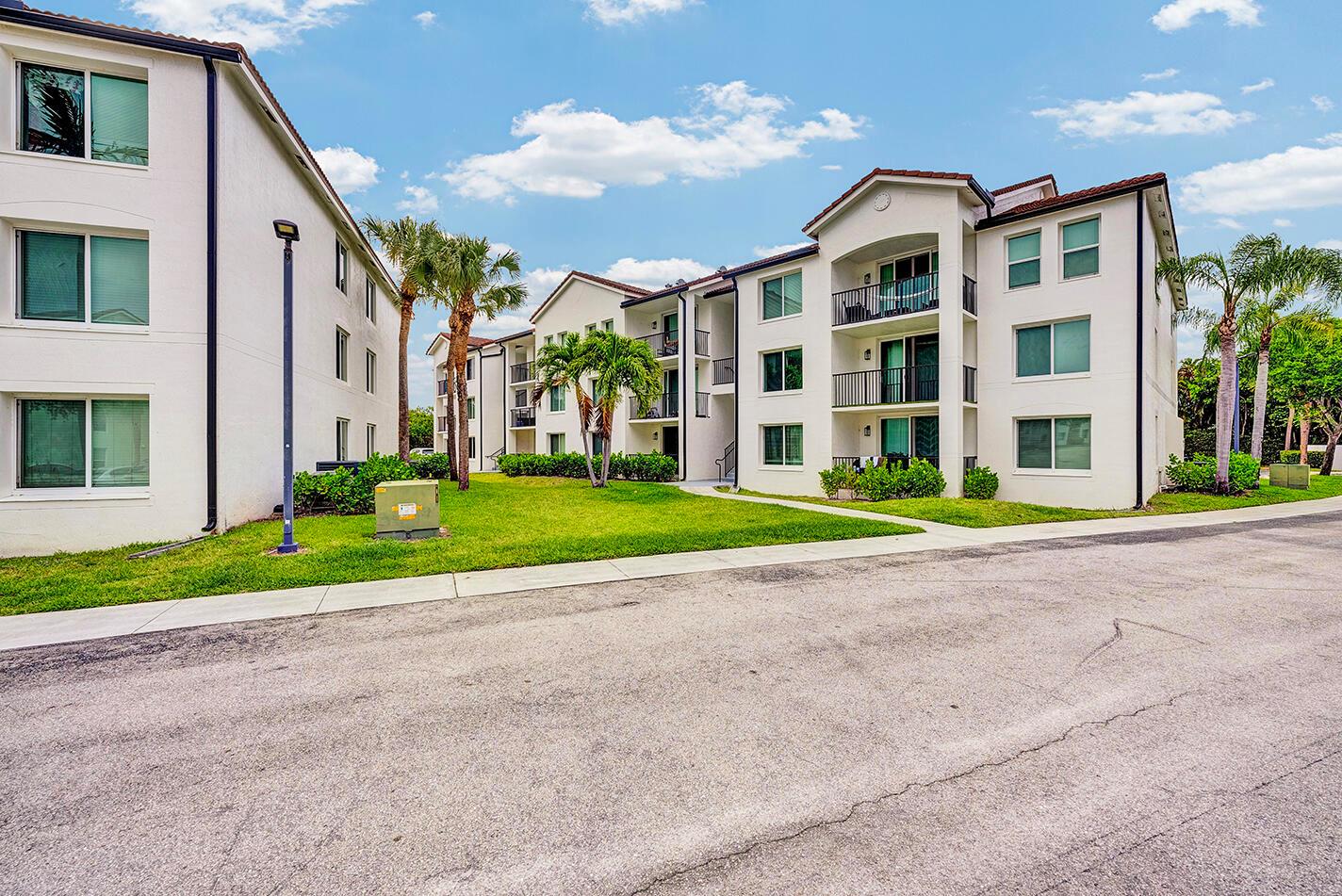 A multi-story apartment building with white stucco walls, dark roofs, and palm trees — 1010 Villa Circle, Boynton Beach FL 33435, BOYNTON BEACH, FL