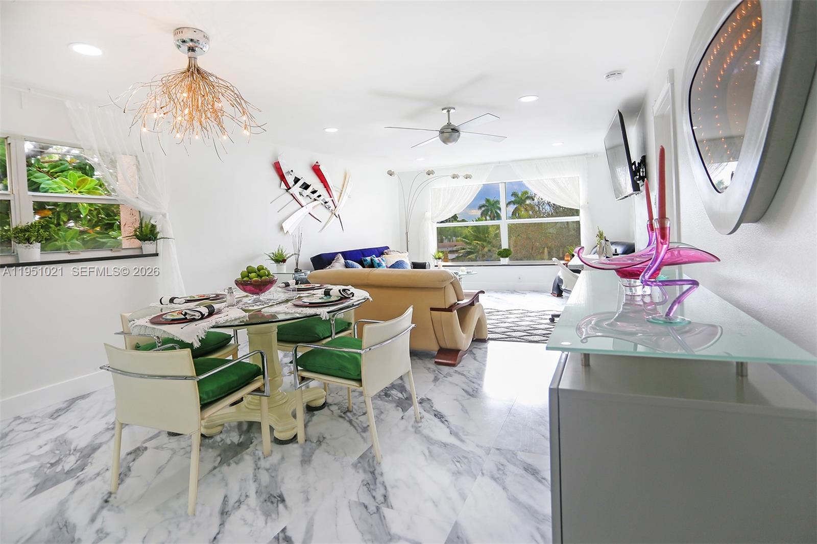 A dining and living area features marble floors, a glass table, and large windows — 6570 Royal Palm Blvd # 301J, Margate FL 33063, MARGATE, FL