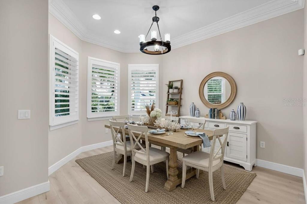 A dining room features a wooden table, chairs, a sideboard, and a chandelier — 2306 64TH STREET W, BRADENTON, FL
