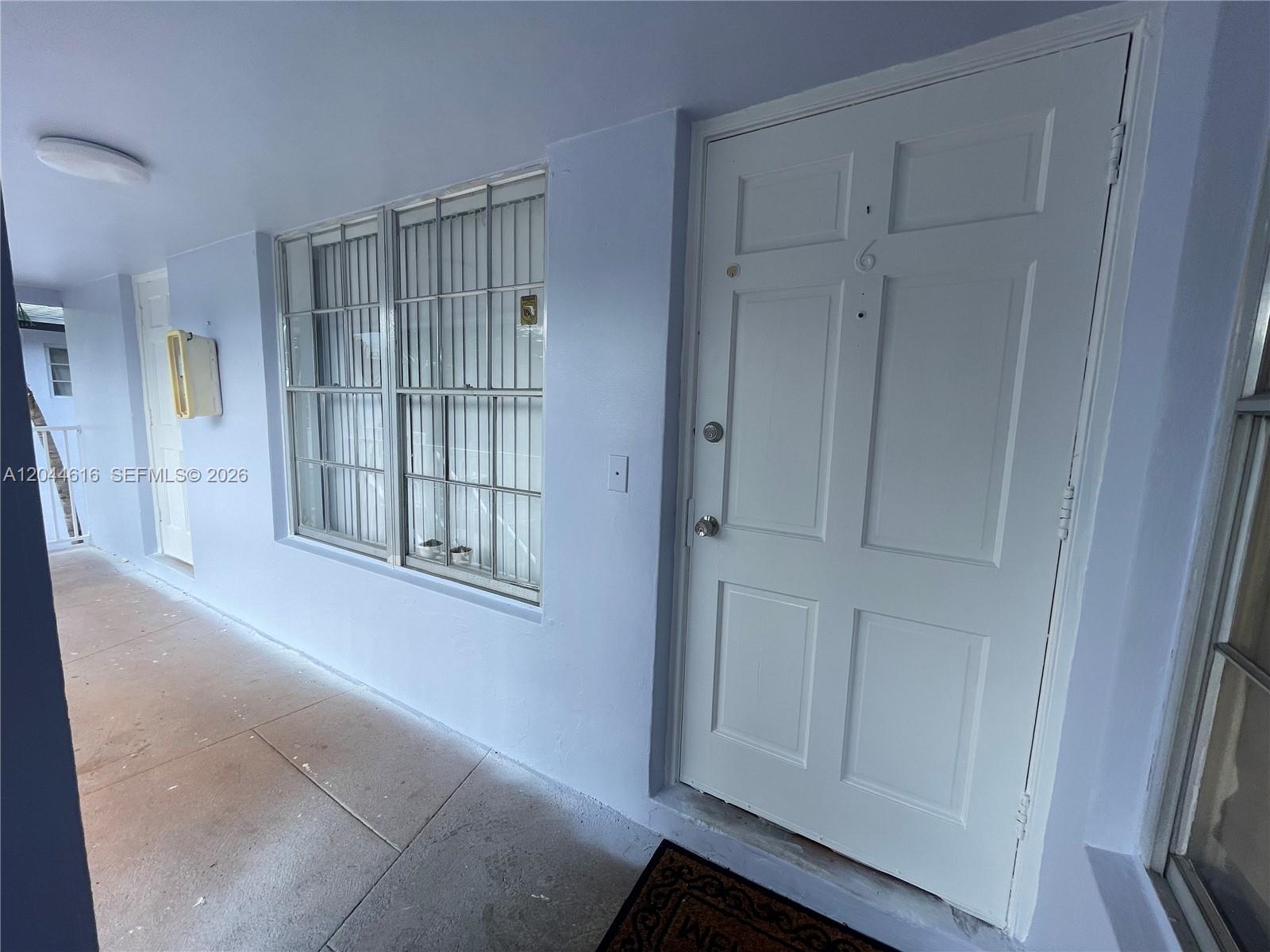 A white door with the number six sits beside a window with security bars — 7841 Dunham Blvd # 6, Miami FL 33138, MIAMI, FL